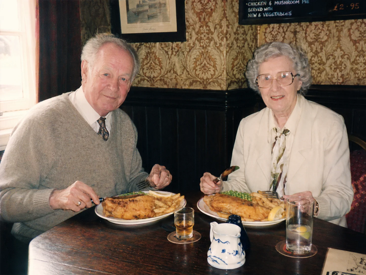 صورة عفوية هاوية لزوجين كبيرين يجلسان في حانة يوركشاير تقليدية مع سمك وبطاطس